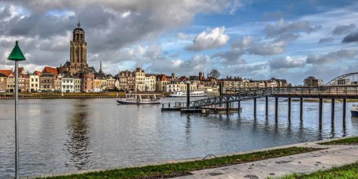 De skyline van Deventer met de Lebuinuskerk, de veerpont en de nieuwe schipbrug, gezien vanaf de Worp bij het IJsselhotel met