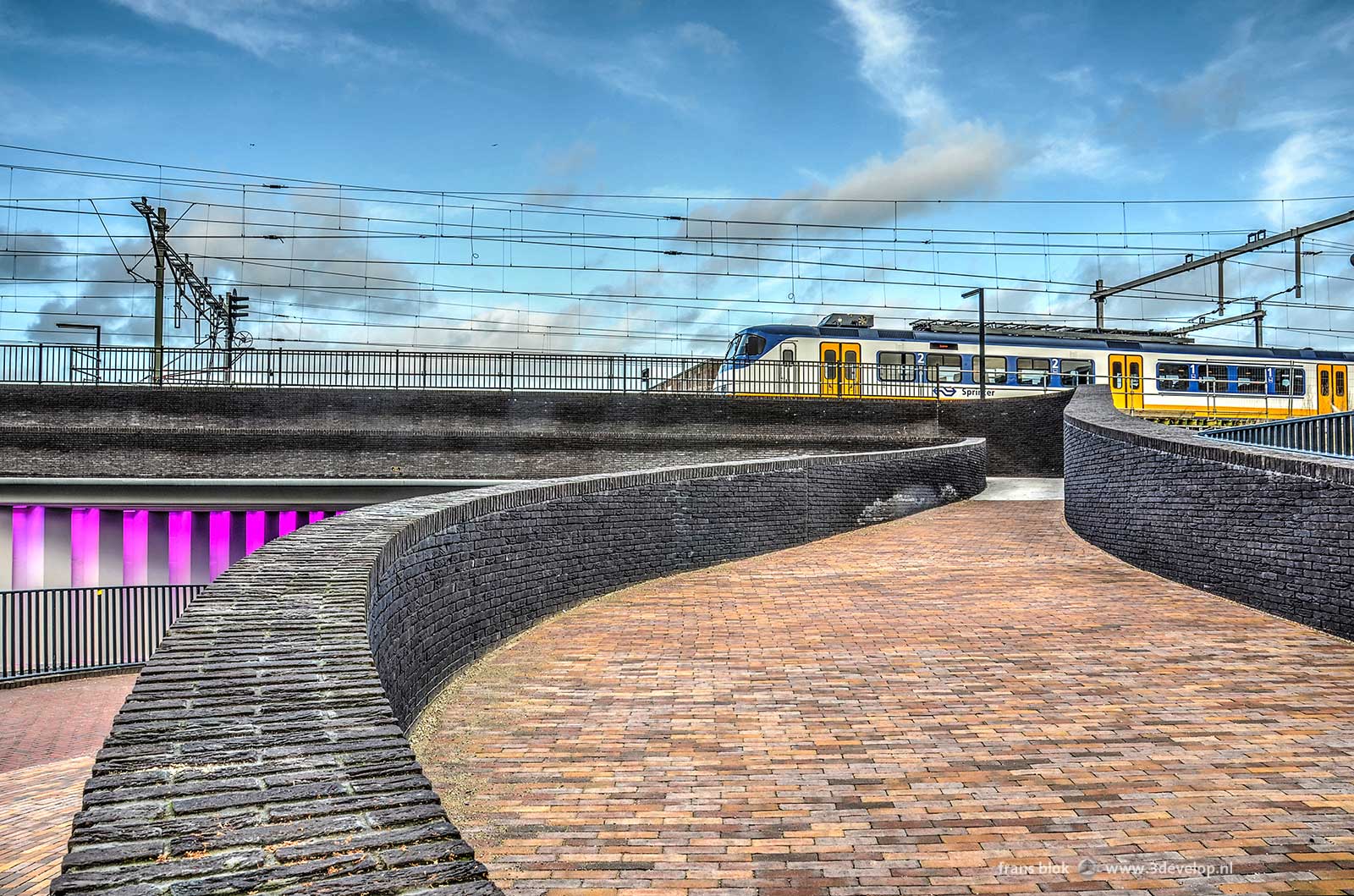 Phto of the Marstunnel in Zutphen with above it the railway station and a train from Dutch Railways, seen from the city centre