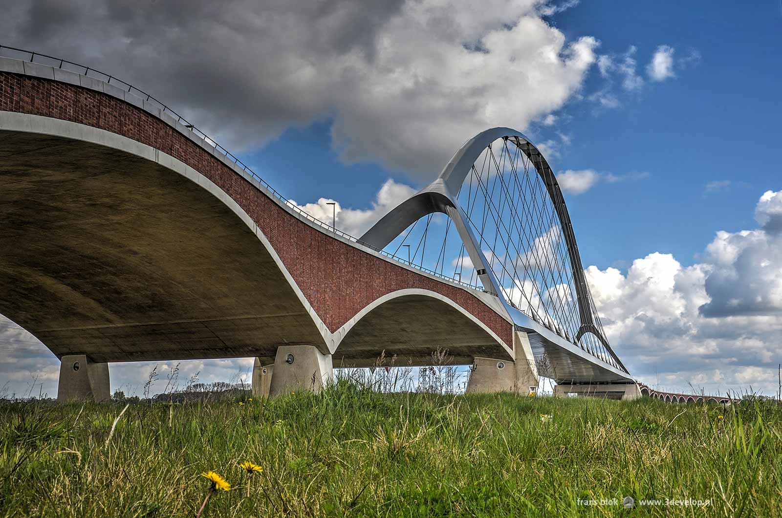 De sierlijke bogen van stadsbrug de Oversteek in Nijmegen, gezien vanaf de zuidelijke oever van de Waal