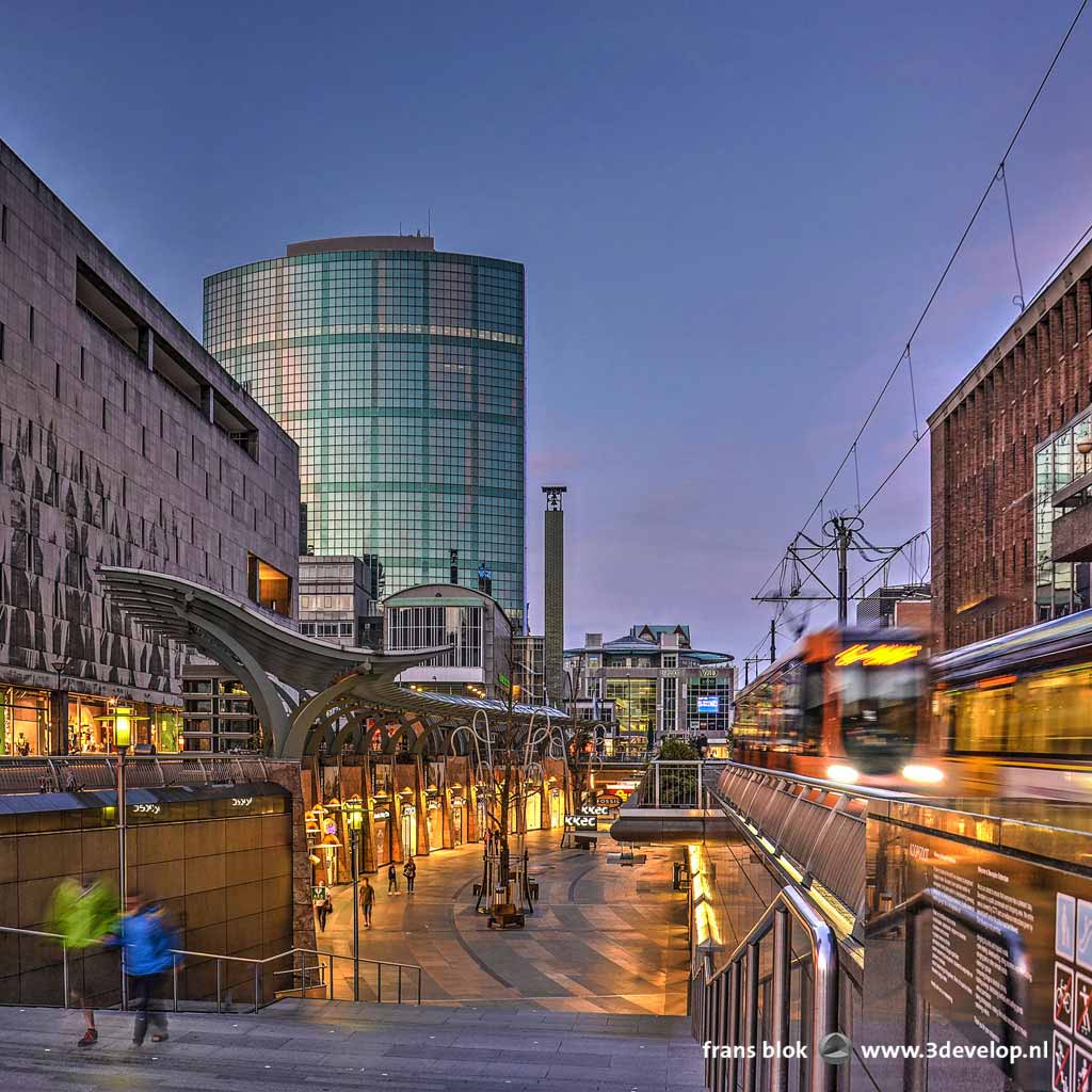 Photo made during the blue hour at the Koopgoot, or shopping gutter in Rotterdam, with illuminated shop windows as well as trams passing by.