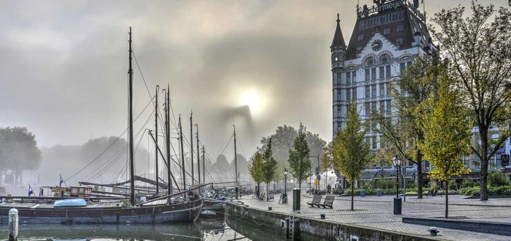 Photo made at the Old Harbour in Rotterdam on a misty day, with the White house and the boats in the harbour in sharp vision but William Bridge as a vague contour.