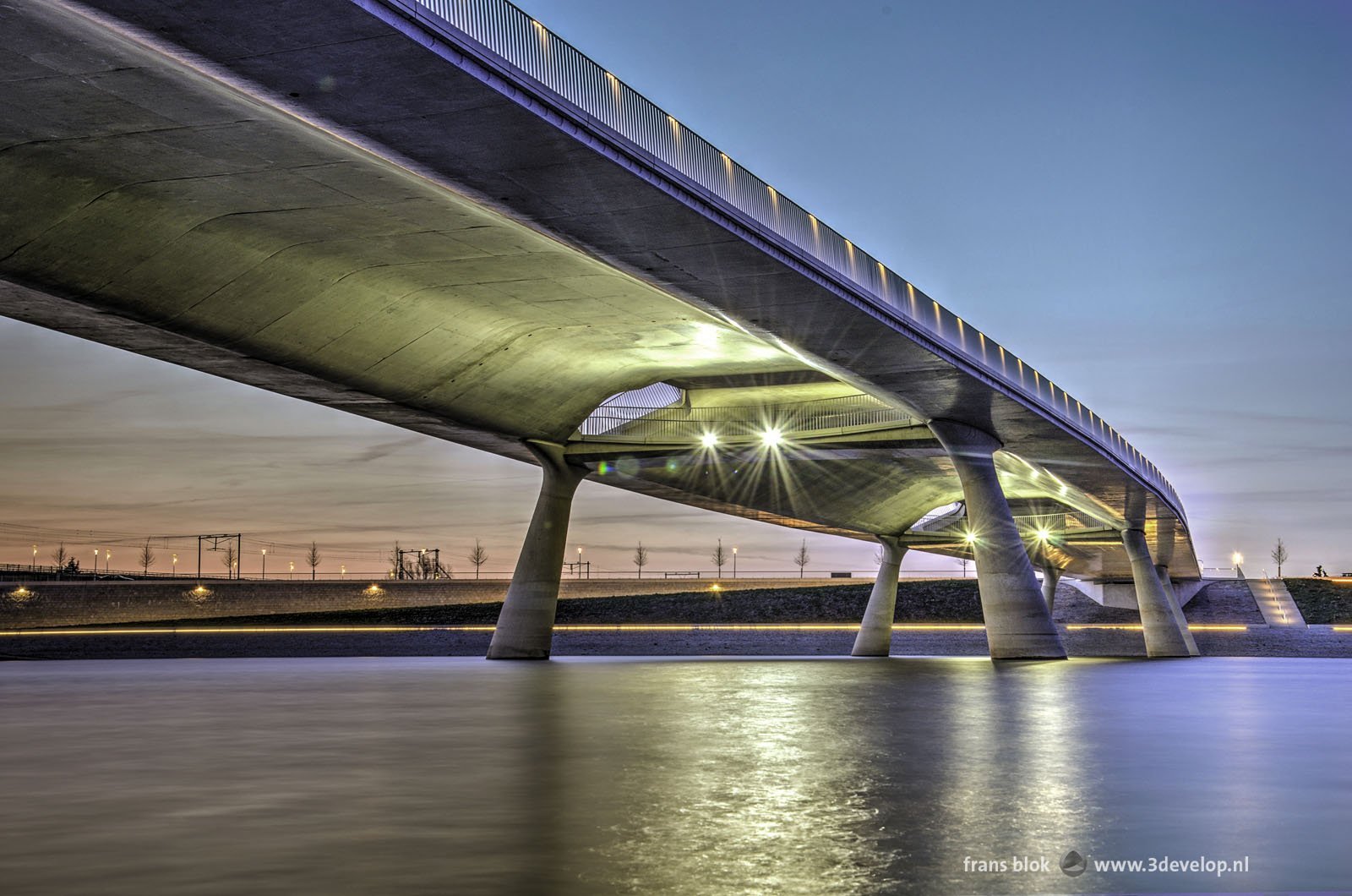 Promenadebrug de Lentloper over de Spiegelwaal bij Nijmegen, gefotografeerd vanaf het eiland Veur-Lent tijdens het blauwe uur