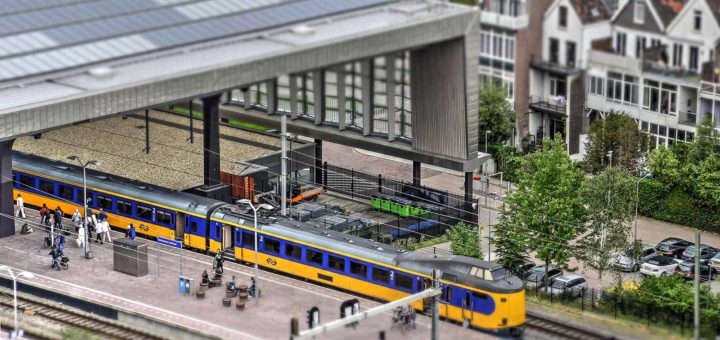 The Miniworld or Madurodam effect on a photo of Rotterdam Central Station featuring a yellow bleu Dutch Railways train