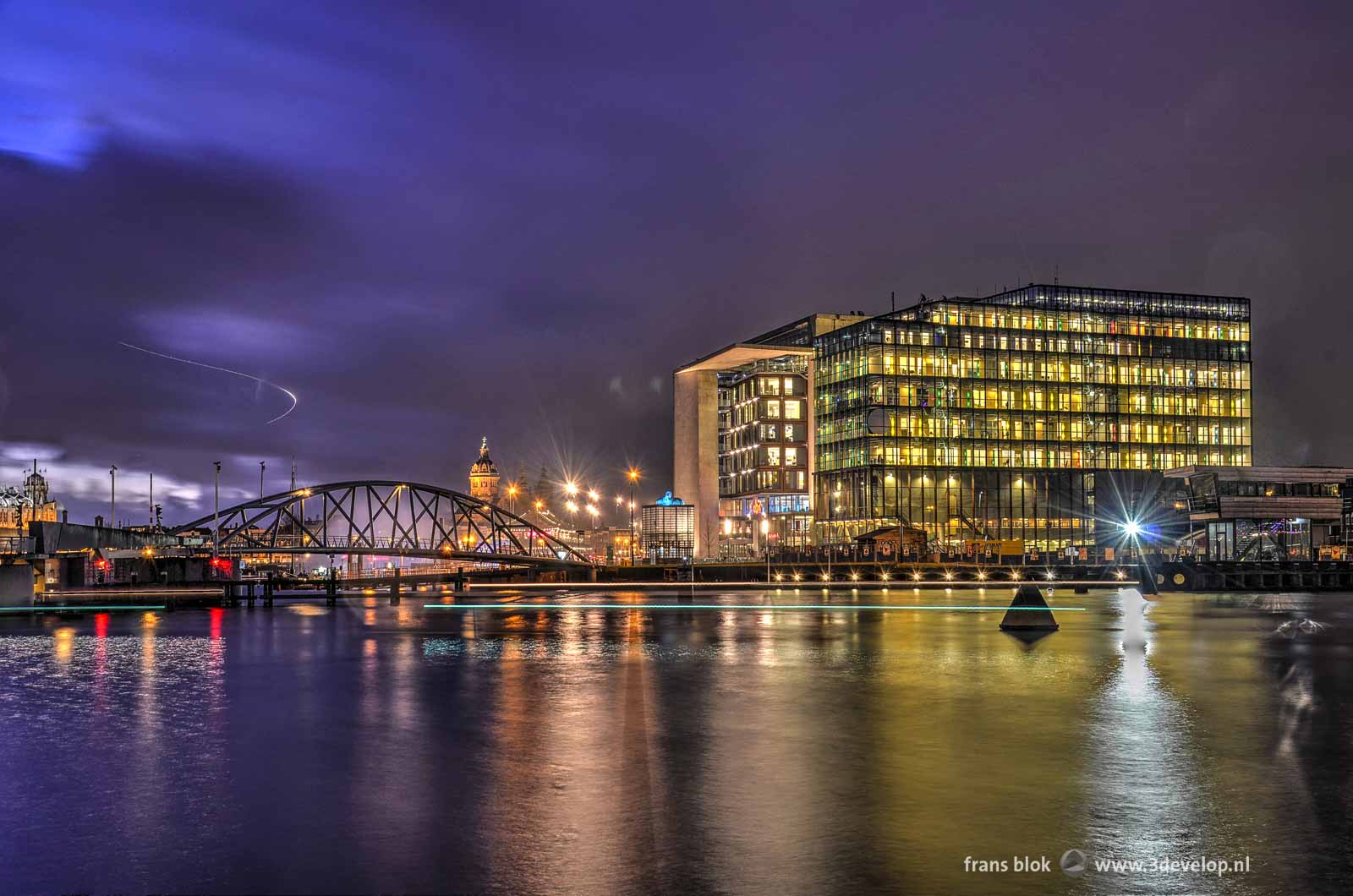 Photo taken during the blue hour after sunset at the Eastern Dock in Amsterdam, featuring the conservatory, the Library and Saint Nicholas Church