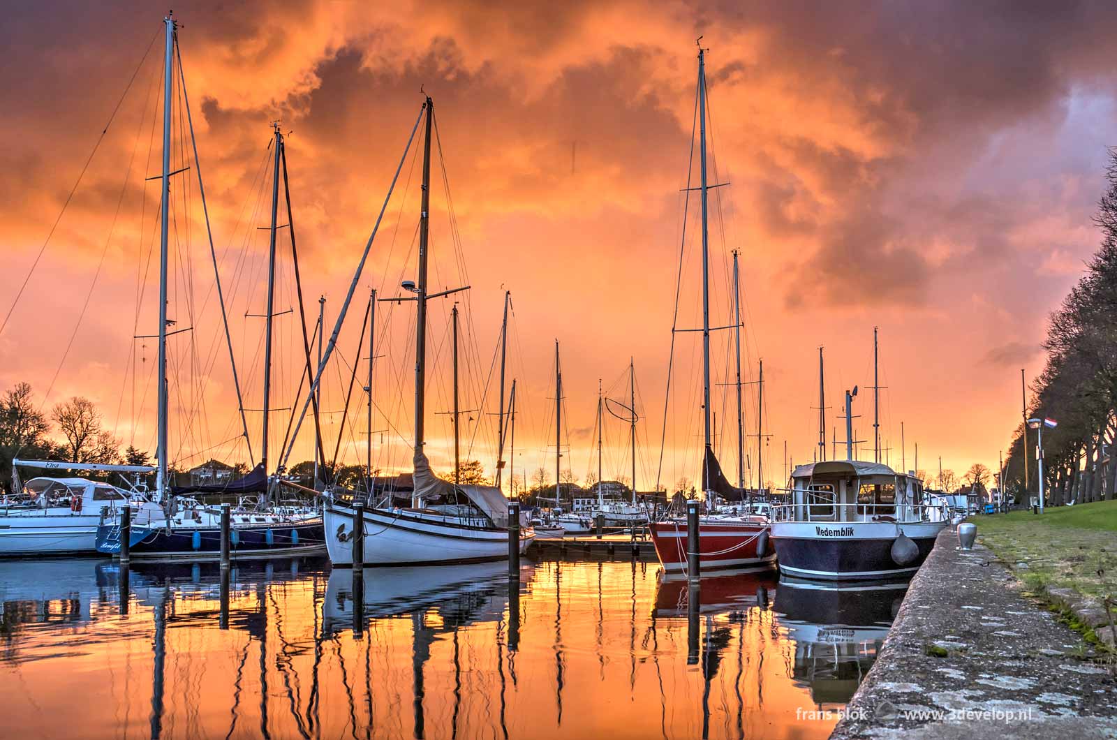 Spectacular red sunset above the sailing yachts in the marina at Medemblik's western harbour in the Netherlands