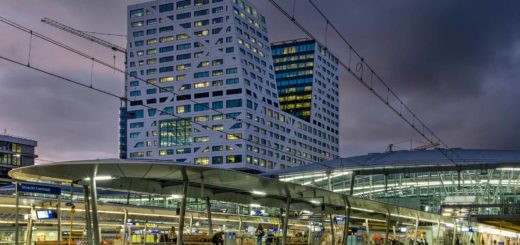 Photo made from one of the platforms on Utrecht Central railway station during the blue hour with the platform canopies, the station hall and the City Office