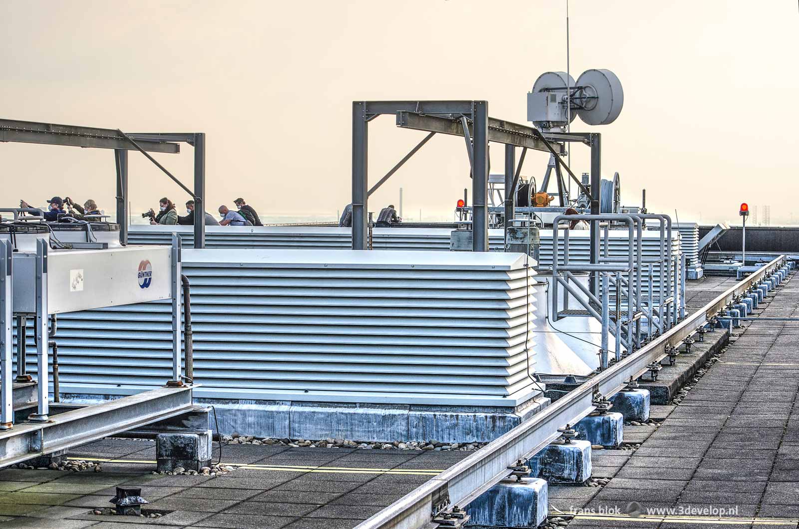 The machinery on the roof of the Delftse Poort building in Rotterdam where a group of photographers is taking pictures