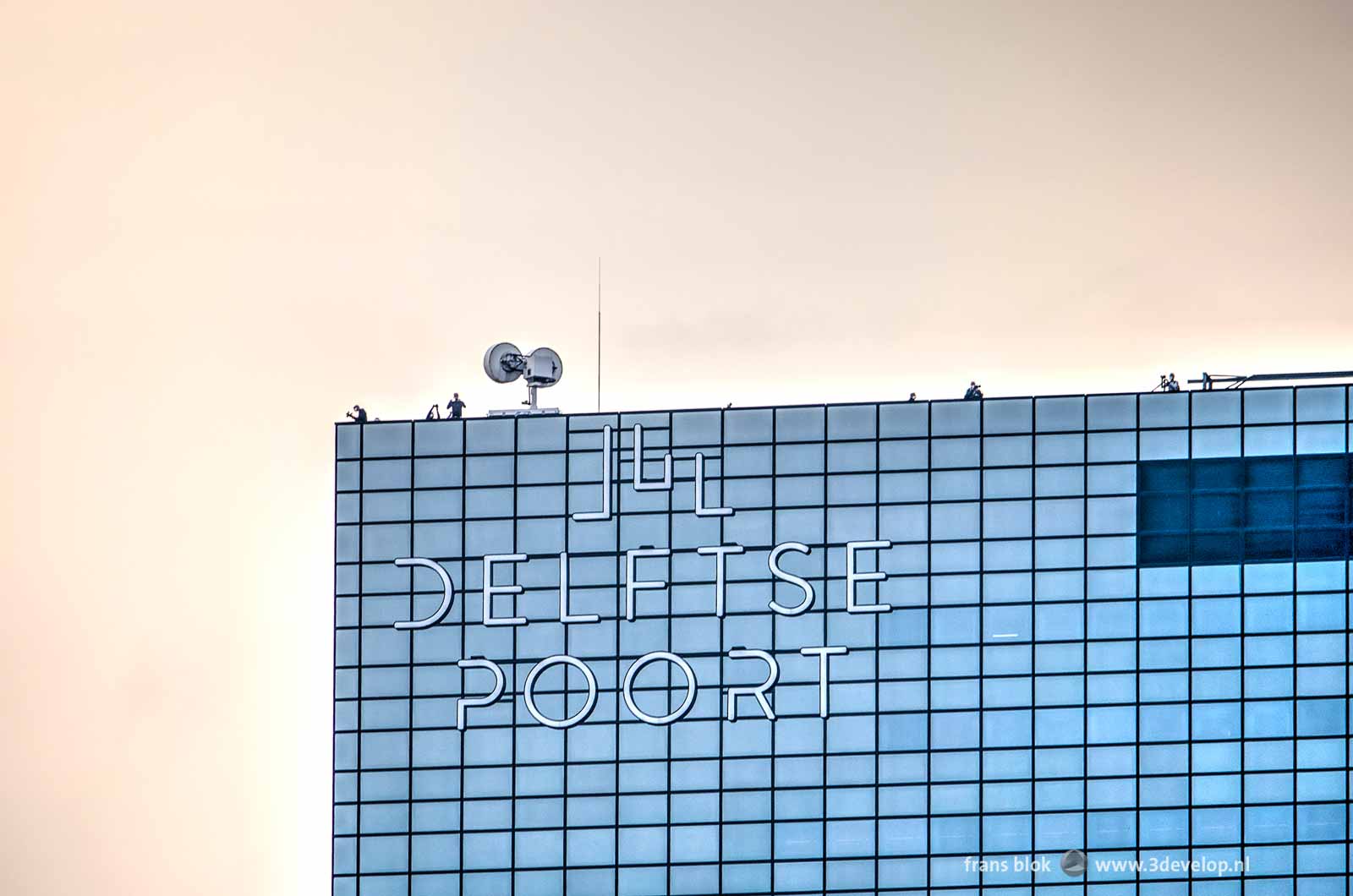 The Delftse Poort building in Rotterdam with some photographers at work on the roof