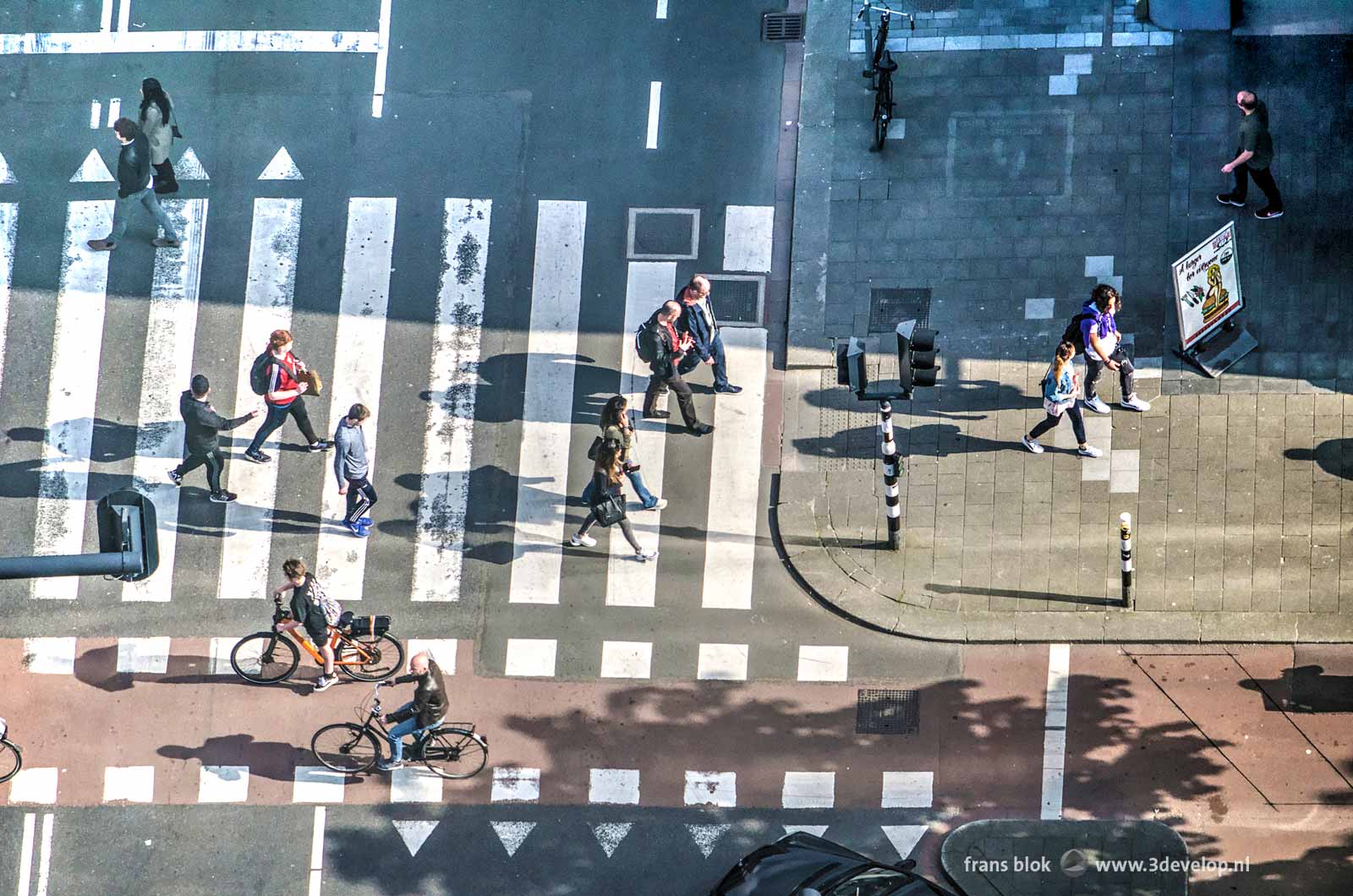 Pedestrians and bicyclists on a street crossing in Rotterdam, seen from above