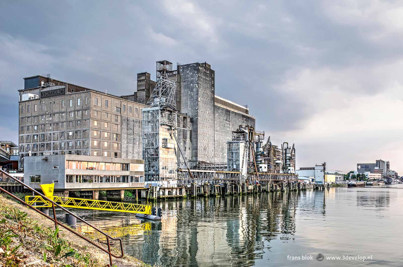 Photograph of the Maassilo in rotterdam, seen from the eastern quay of Maashaven harbour below the metro tracks on a nice summer evening