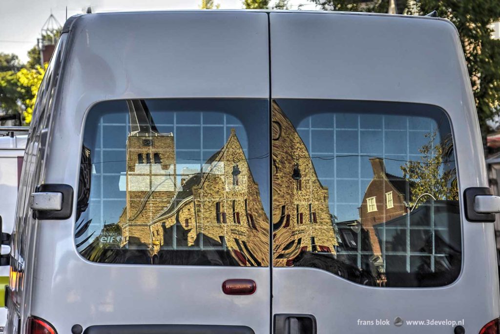 Martini church in Franeker, The Netherlands, reflecting in the rear window of a white van