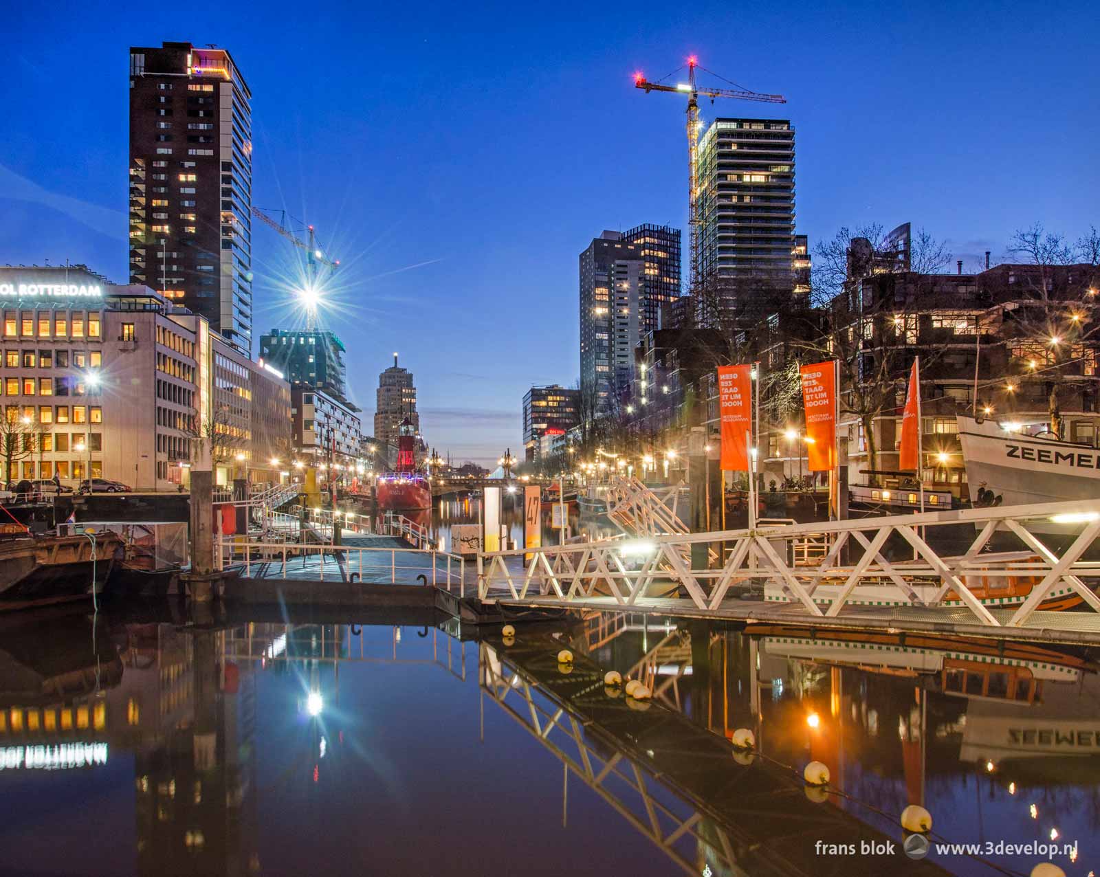 The floating pontoon bridge across Leuvehaven harbour near the Maritime Museum in Rotterdam during the blue hour before sunrise