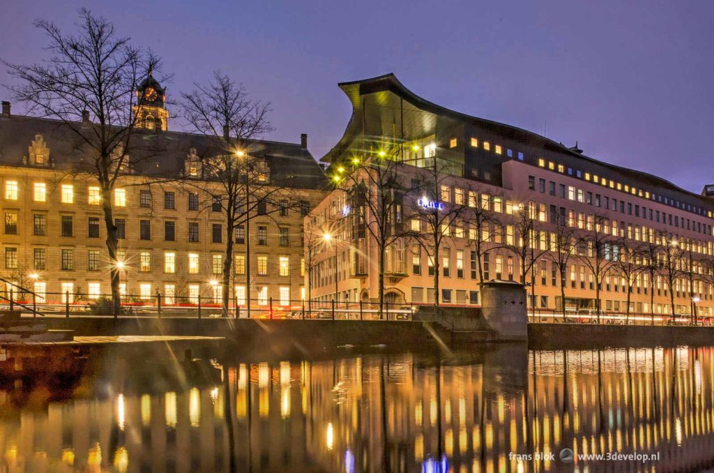 The city hall and the police office in Rotterdam reflecting in the water of Delftsevaart canal during the blue hour on a morning in january