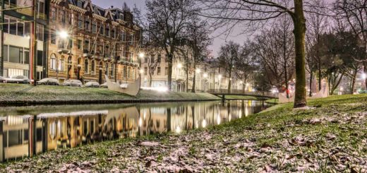 Westersingel canal in Rotterdam in the blue hour before sunset with a very thin layer of snow on the grassy banks