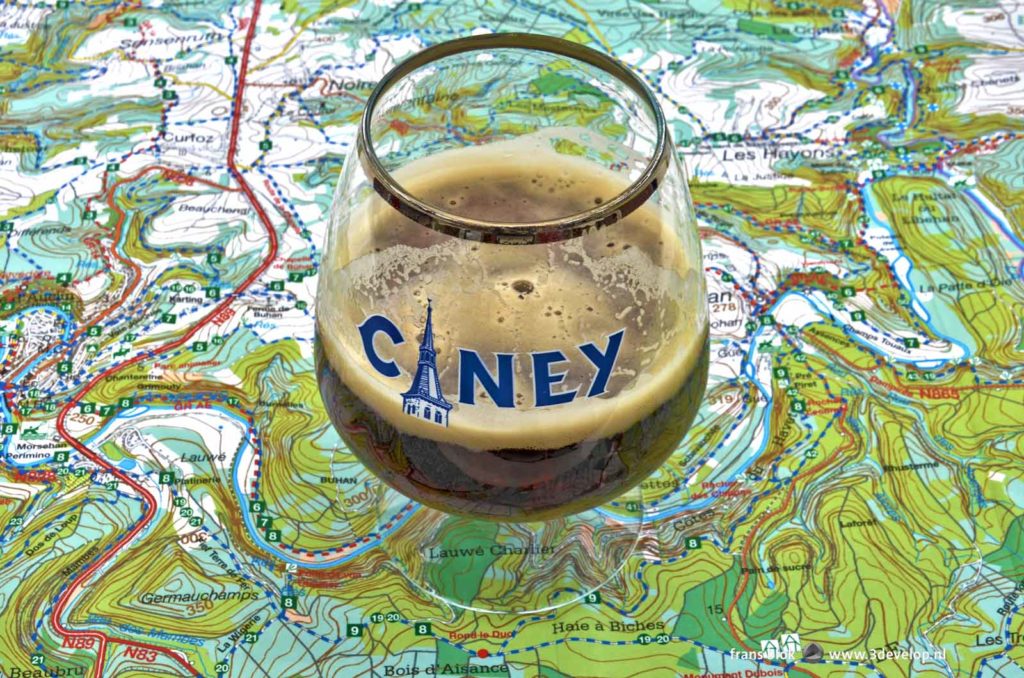 Half full glass of Ciney beer on a hiking map of the Belgian Ardennes