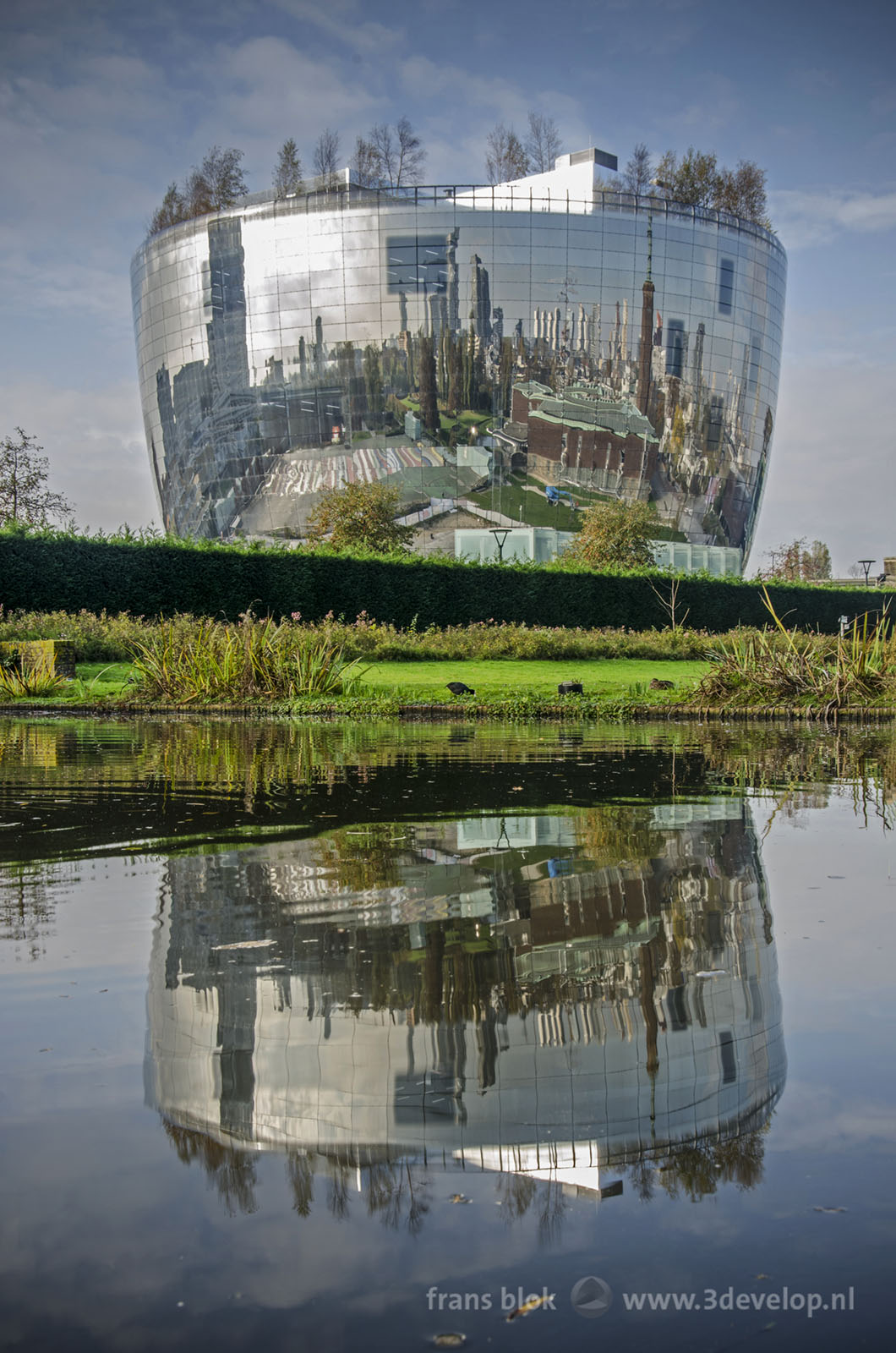 Het spiegelende collectiegebouw van museum Boymans in Rotterdam, ook wel het depot of De Pot genoemd, spiegelend in een vijver in het Museumpark