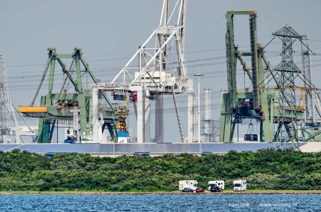 Drie campers aan de noordoever van het Oostvoornse meer, met op de achtergrond de reusachtige haveninstallaties van Rotterdam Europoort