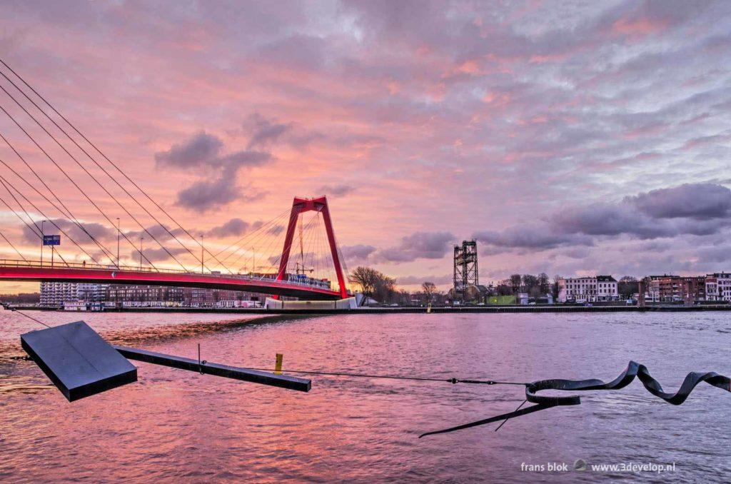 Nieuwe Maas river, Waslijn sculpture, Willemsbridge and Noordereiland in Rotterdam, The Netherlands under a spectacular sky at sunrise