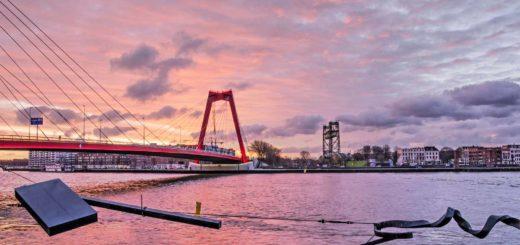 Nieuwe Maas river, Waslijn sculpture, Willemsbridge and Noordereiland in Rotterdam, The Netherlands under a spectacular sky at sunrise