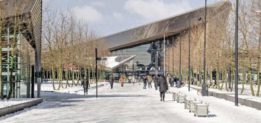 Kruisplein square in Rotterdam, covered with compact snow and in the background the Central Station on a sunny day in the winter of 2021