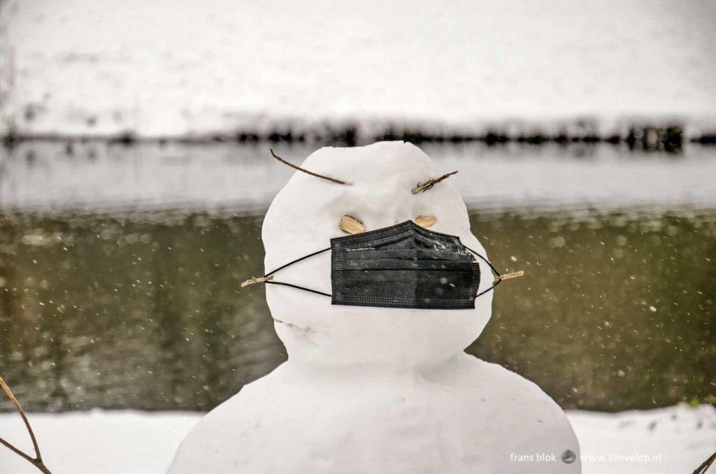 Snowman with a black facemask in The Park in Rotterdam during the winter of 2021