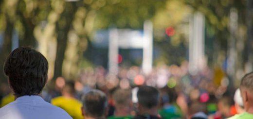 Marathon runner seen on the back with a blurry background of hundreds of other runners during the Rotterdam marathon in 2021