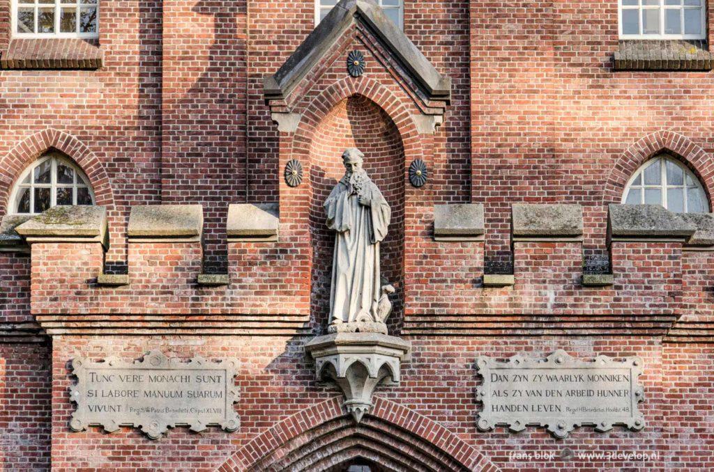 Detail of the Koningshoeven abbey near Tilburg, The Netherlands, with statue and proverbs