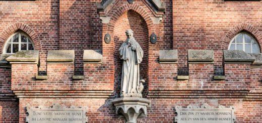 Detail of the Koningshoeven abbey near Tilburg, The Netherlands, with statue and proverbs