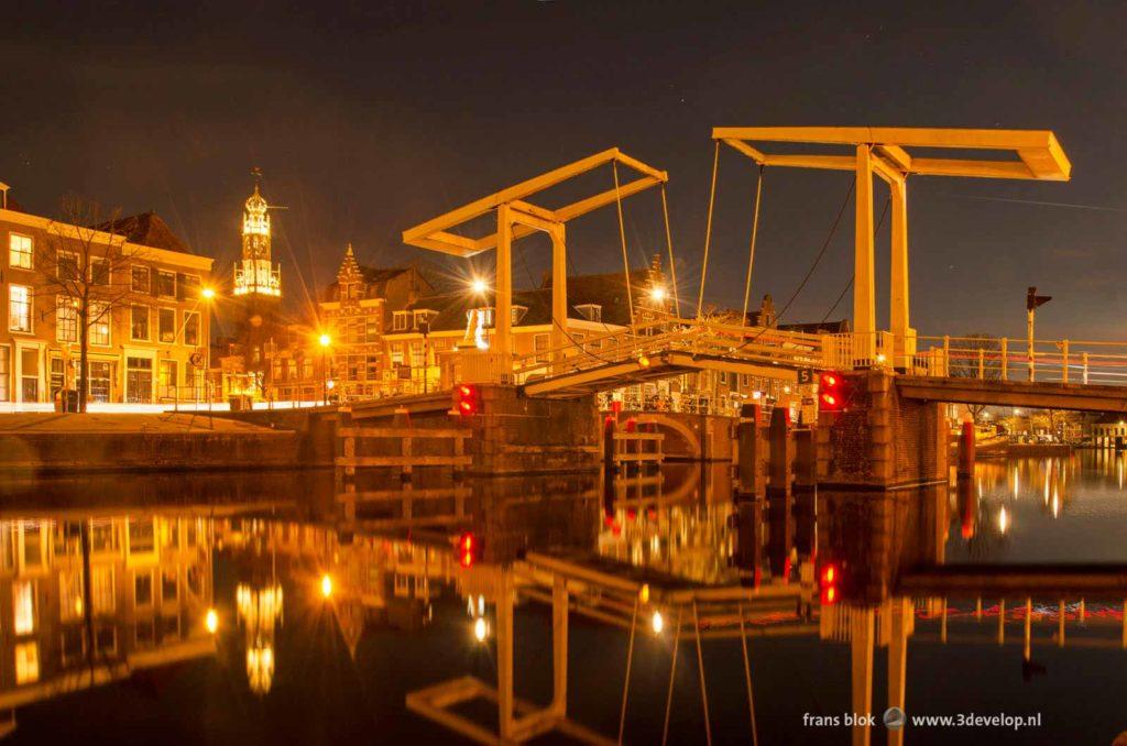 Traditional wooden drawbridge reflecting in the river Spaarne in Haarlem, The Netherlands, on a windless evening