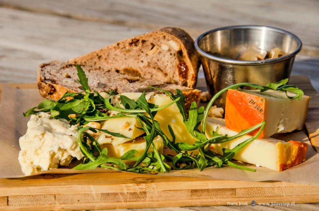 Cheese plate with three cheeses, rucola, bread and chutney