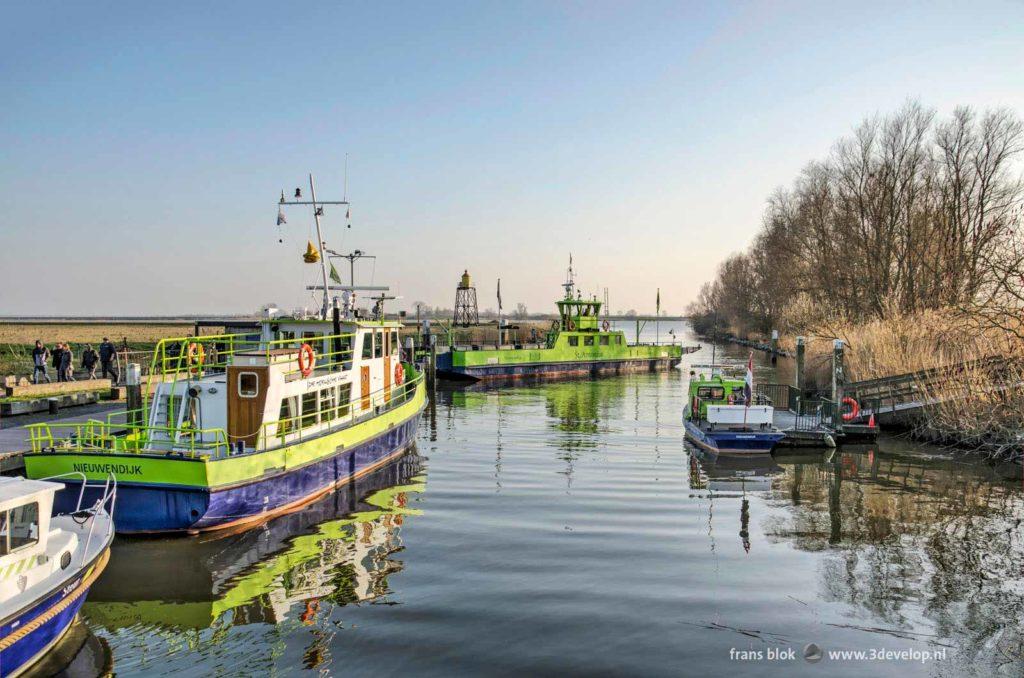 Various ferry boats in the little harbour of Nieuwendijk, The Netherlands, with in the background Haringvliet estuary and the island of Tiengemeten