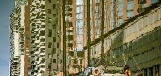 Historic barges and modern residential buildings, reflected in the water of Wijnhaven harbour in Rotterdam, The Netherlands