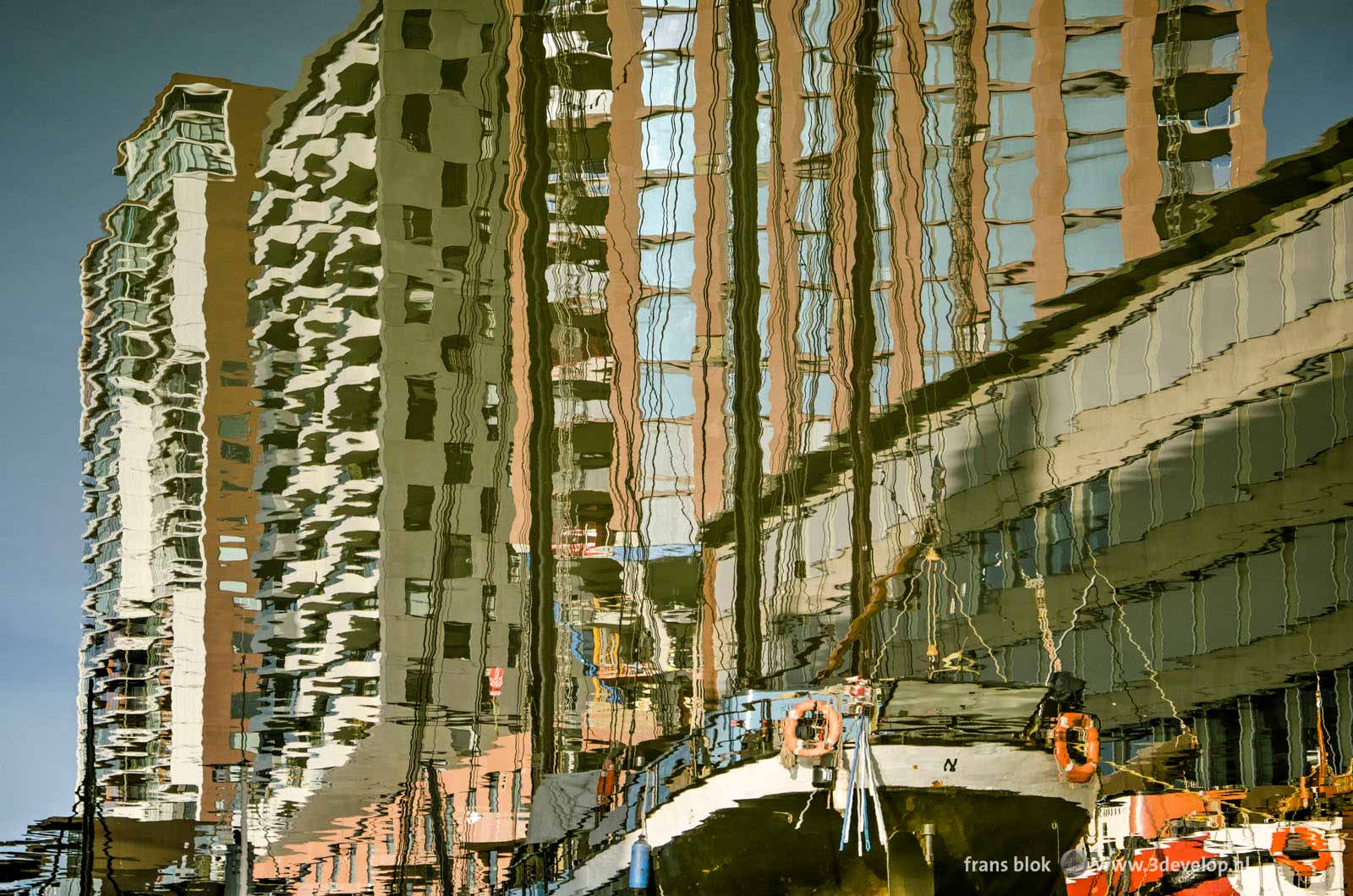 Historic barges and modern residential buildings, reflected in the water of Wijnhaven harbour in Rotterdam, The Netherlands