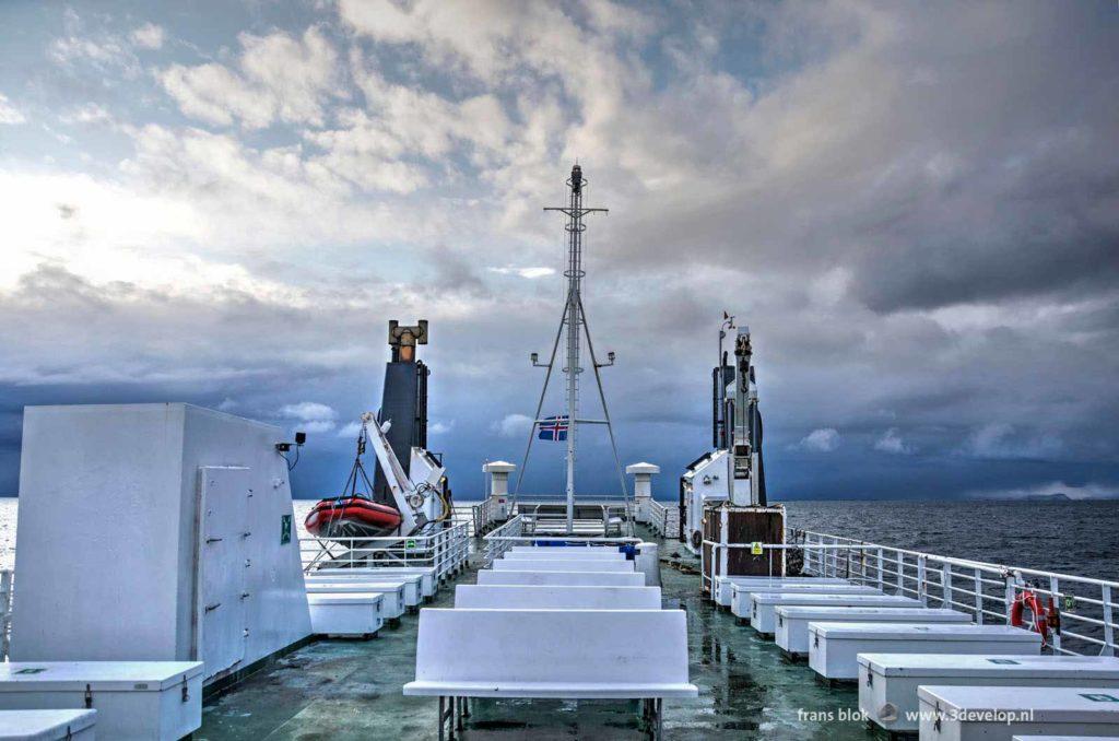 Uitzicht vanaf veerboot de Baldur in IJsland op de zee en een dreigende lucht