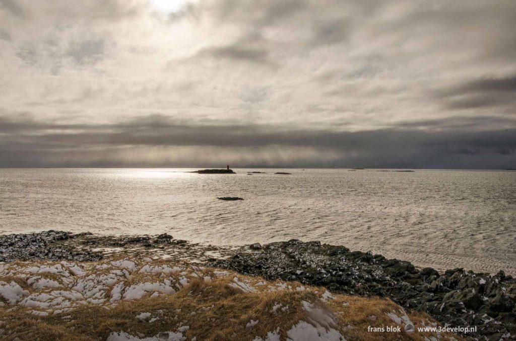 Fraaie lucht boven de Breiðafjörður, gezien vanaf het gedeeltelijk met sneeuw bedekte eiland Flatey in IJsland