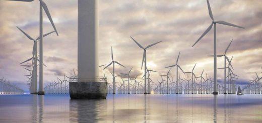 Wind farm in the North Sea seen from a low point of view against a spectacular evening sky with a sailing boat as a scale element