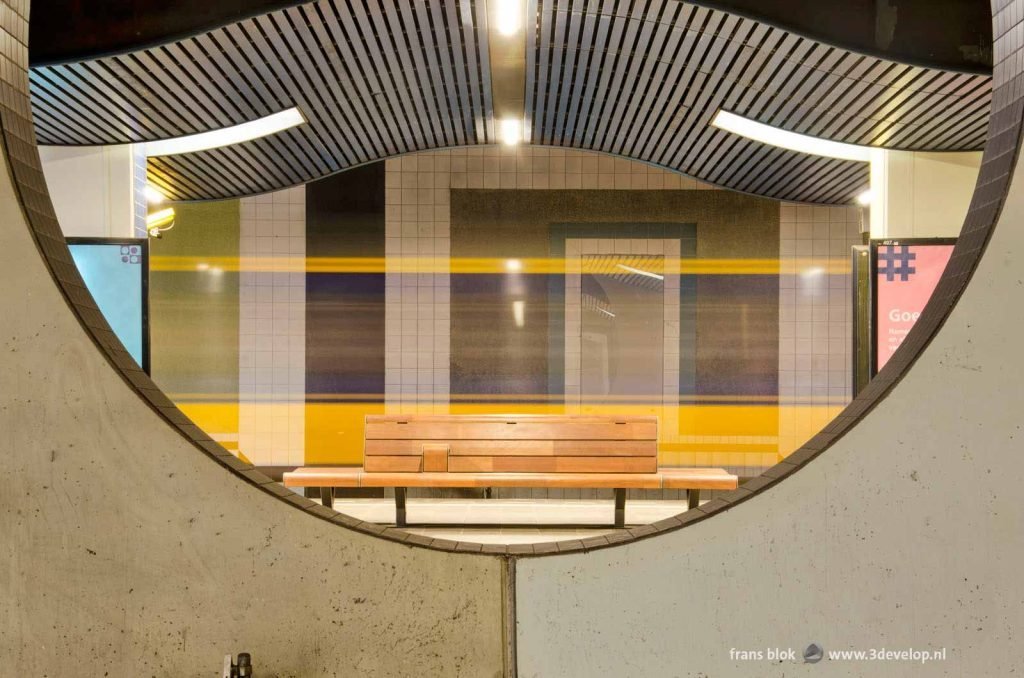 Symmetric image of construction and ceiling on Rotterdam Blaak underground railway station, with a passing train