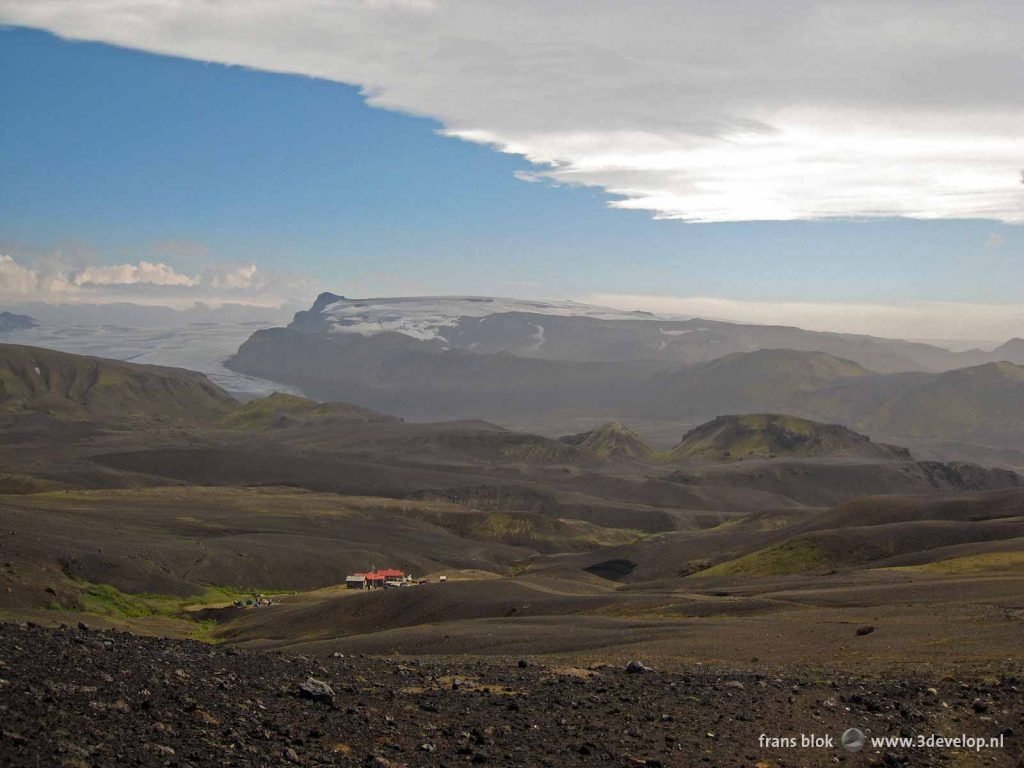 Landscape with hills and gorges, a hikers refuge and a giant glacier near Emstrur, Iceland