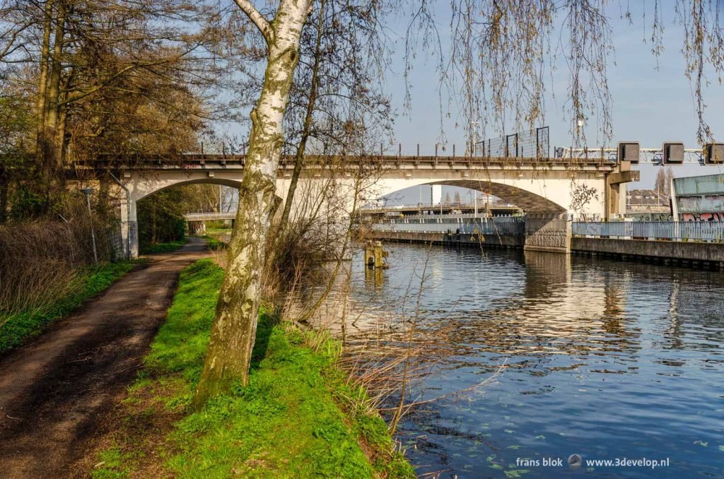 Walking path along the Noorder Canal in Rotterdam with the highway and the old Hofplein viaduct