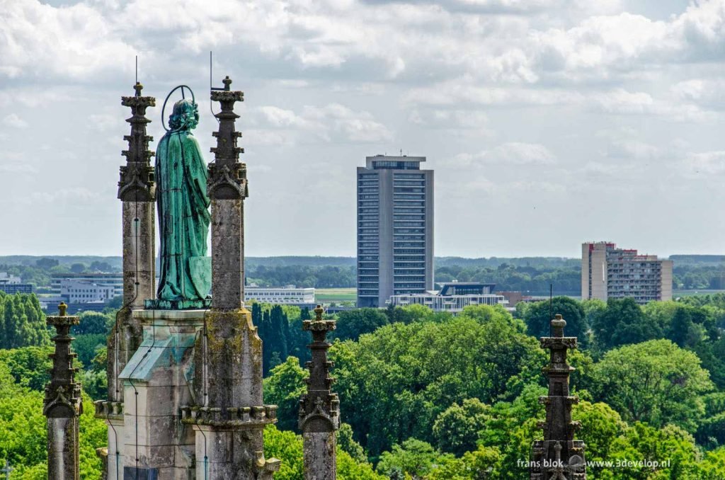 Sculpture of Saint John the Baptist on Saint John's cathedral in Den Bosch, The Netherlands, with the Province office in the background