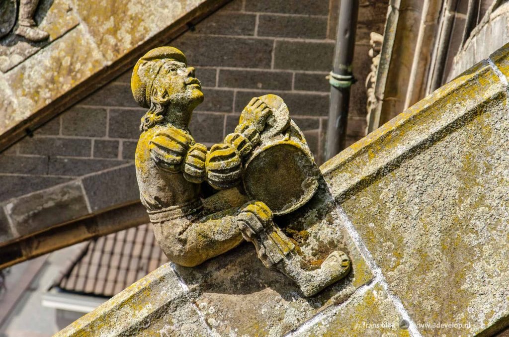 Scultpture of a craftsman on a support structure on Saint John's cathedral in Den Bosch, The Netherlands