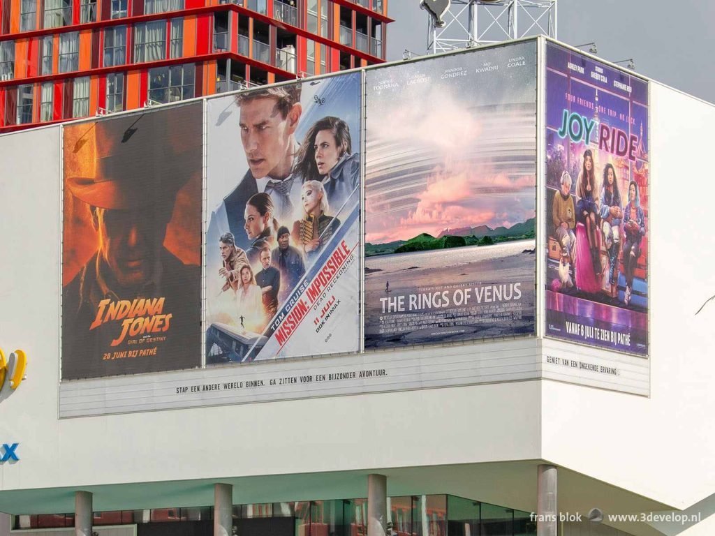 Four movie posters, one of them fake, on the facade of the Pathe cinema on Schouwburgplein in Rotterdam, The Netherlands