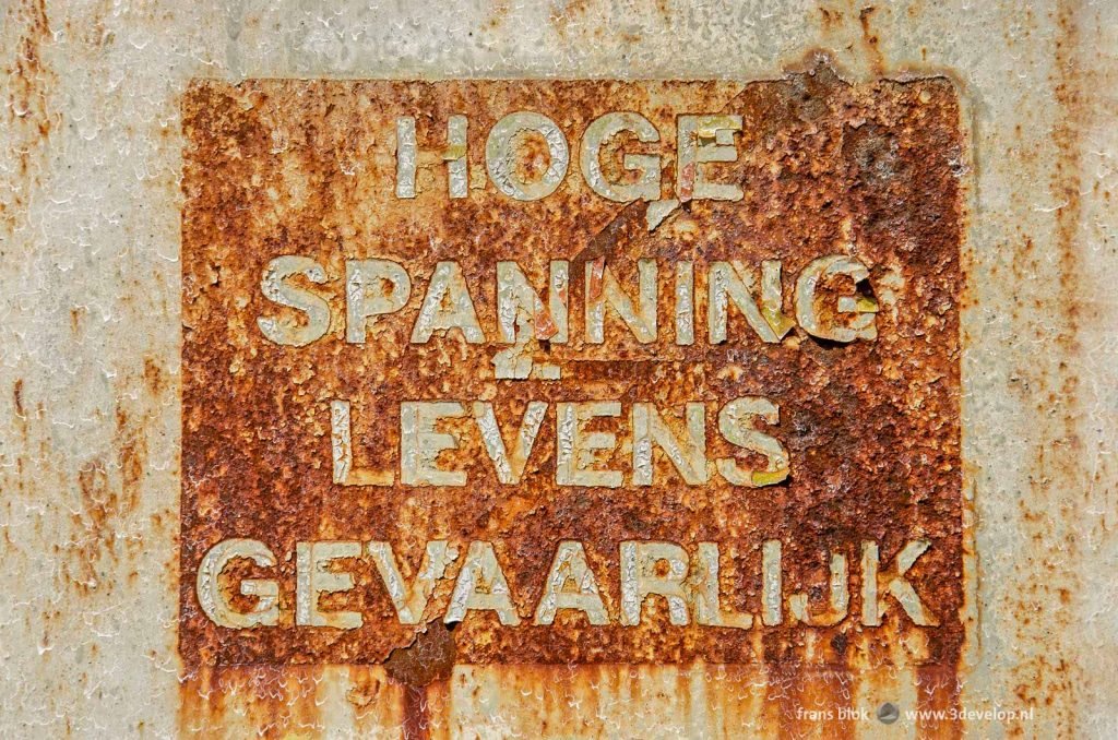 Rusty sign with the text, in Dutch "high voltage mortal danger"