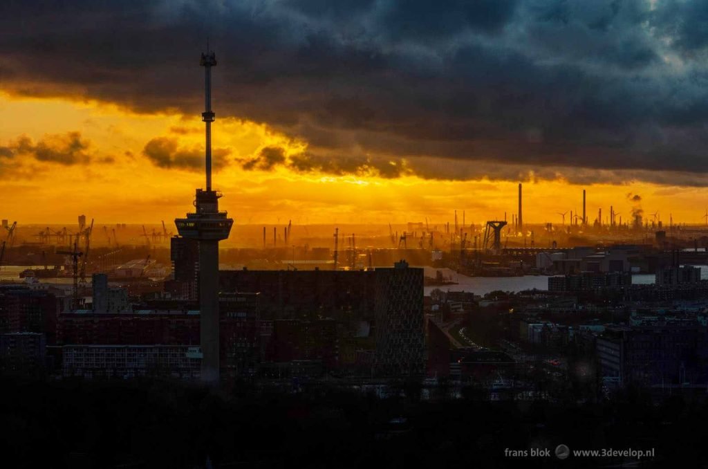 Fiery sunset in the harbour of Rotterdam behind the Euromast