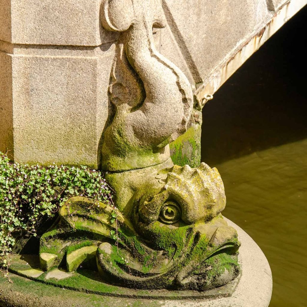 Sculpture of a fish, partly covered with seaweed and other vegetation, on Regentesse bridge across Wijnhaven harbour in Rotterdam