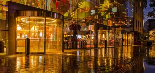 Het interieur en kunstwerk van de Markthal in Rotterdam weerspiegelt in de natte bestrating tijdens de avondschemering